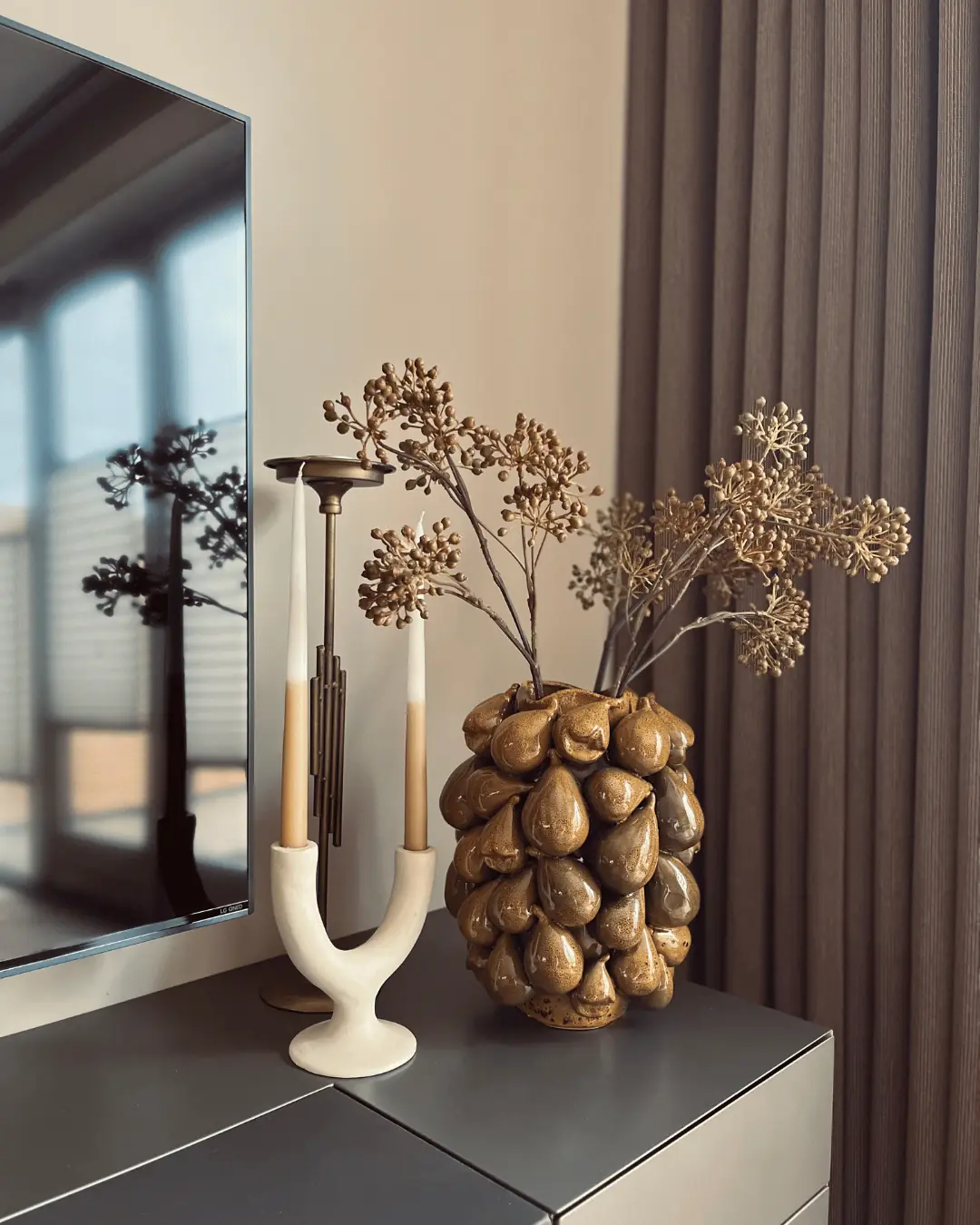 Dressoirstyling met gouden vaas, droogbloemen en een witte kandelaar