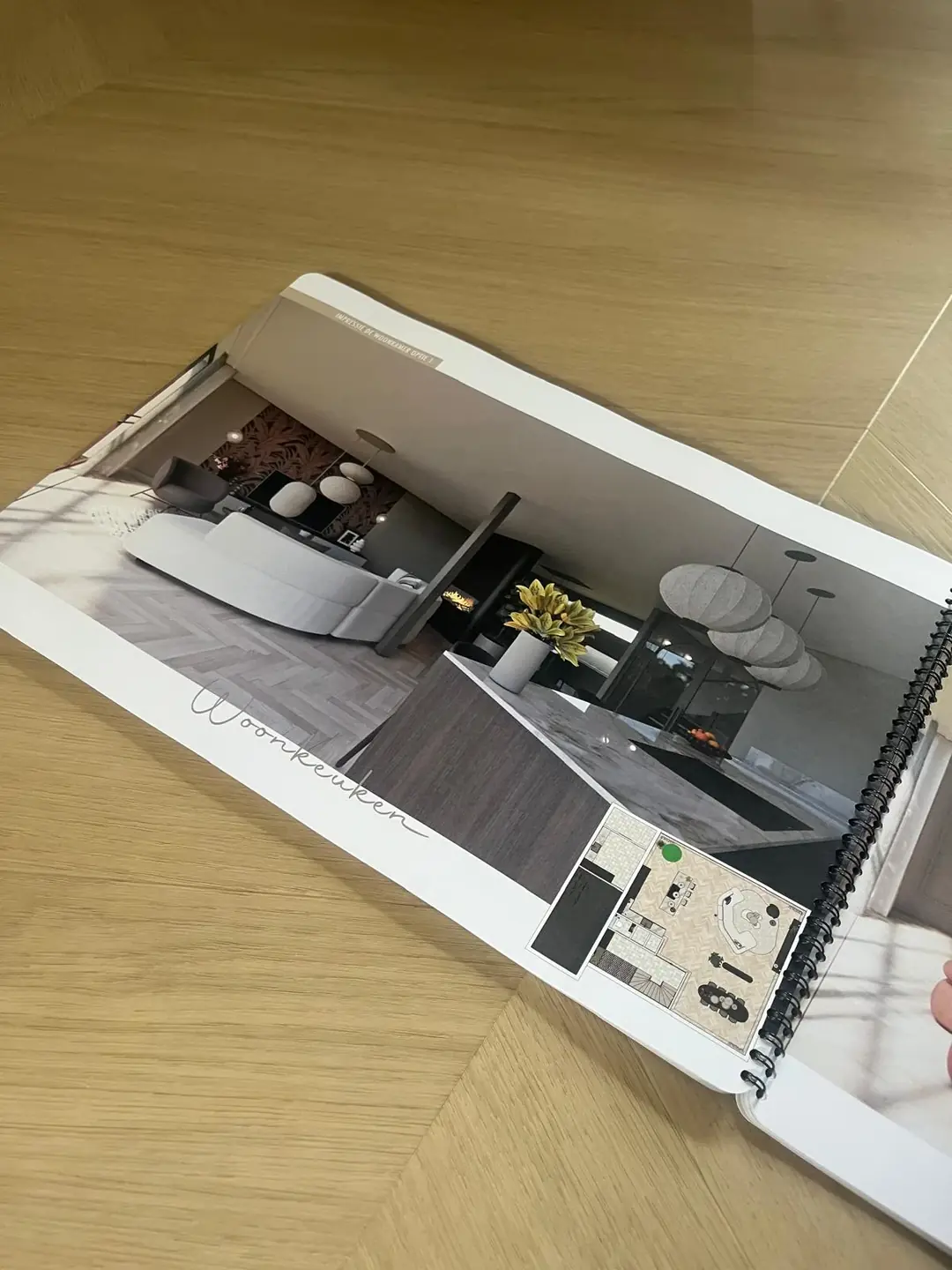 Ontwerpboek open op de impressie van de woonkeuken met de plattegrond in de hoek